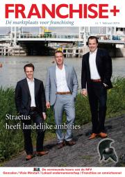 Drie mannen in pakken poseren langs een waterkant met een brug op de achtergrond, op de cover van Franchise+ nummer 1.
