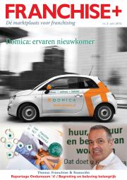 Witte Fiat 500 met Domica-branding tegen stedelijke achtergrond, bijgestaan door sleutelhangers en glimlachende man.
