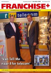 Twee mannen in pakken staan in een t for telecom-winkel met accessoires aan de wanden.