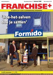 Drie mannen poseren met bouwmaterialen op een karretje voor een Formido-winkel.