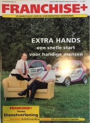Twee mannen in zakelijke kleding zitten buiten op gele stoelen voor auto's met Extra Hands branding.