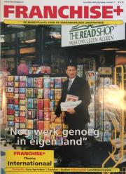 Man voor The Read Shop met kranten en tijdschriftenrekken, tekstuele accenten op Nog werk genoeg in eigen land.
