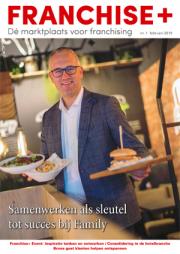 Man in pak met twee borden eten in een restaurantomgeving, op de cover van Franchise Plus nummer 1, 2019.