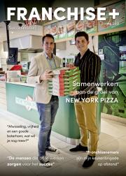 Twee mannen in een New York Pizza-vestiging houden stapels pizzadozen vast.