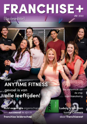 Groep lachende mensen in een sportschool met teksten over Anytime Fitness en franchising.