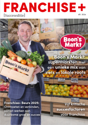 Man bij Boon's Markt met groenten en fruit in een houten krat, supermarkt in de achtergrond, Franchise+ logo bovenaan.