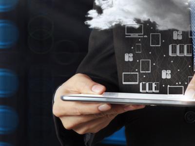 Man in pak met tablet, uit wolk komen digitale iconen van technologie en communicatie naar voren.