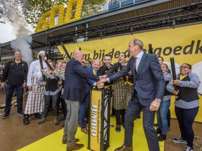 Feestelijke opening van de 600e Jumbo winkel in Vught met lachende medewerkers en gele ballonnen in de achtergrond.