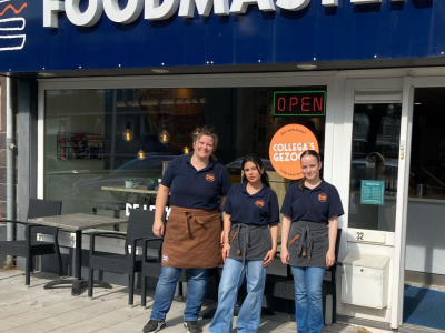 Drie medewerkers staan voor de ingang van Foodmaster Alphen onder een bord met de tekst Collega's gezocht.