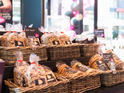 Mand met verpakte muesli en beschuit uitgestald in een Bakker Bart winkel.