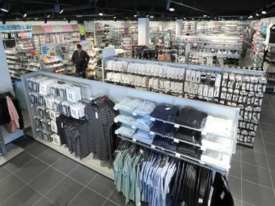 Interieur van een goedgevulde HEMA-winkel met diverse kleding en huishoudelijke artikelen op overzichtelijke schappen.