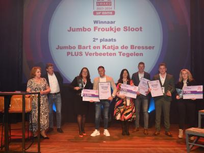 Froukje Sloot staat met anderen op het podium tijdens de prijsuitreiking voor beste zelfstandig supermarktondernemer.