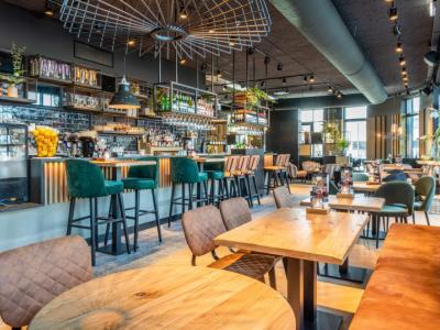 Interieur van restaurant De Beren Roosendaal met een moderne bar, houten tafels en sfeervolle zitplekken.