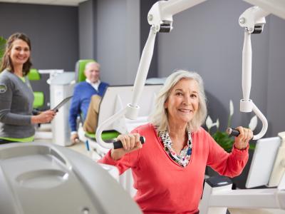 Senioren trainen met begeleiding bij fit20, terwijl ze fitnessapparatuur gebruiken in een moderne studio.