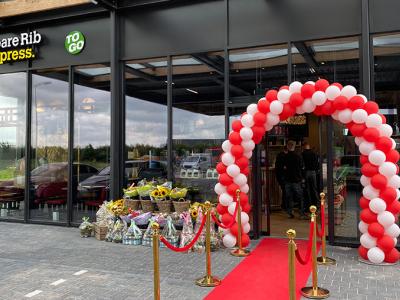 Spare Rib Express To Go flagshipstore met rode loper en boog van ballonnen bij de entree.