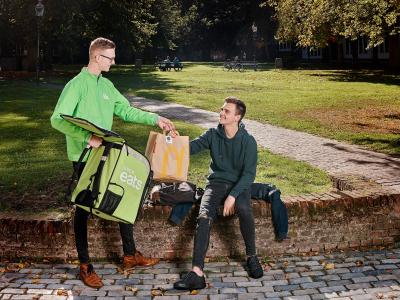 McDonald's bezorging door Uber Eats koerier in park voor de Pieterskerk in Leiden.
