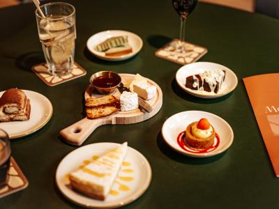 Assortiment van desserts en kaas op tafel met menukaart in een nieuw restaurant in Vlaardingen.