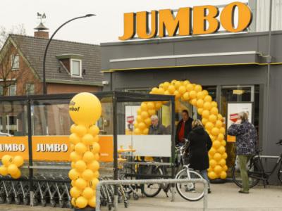 Jumbo-winkel met geel ballonportaal bij de ingang en winkelwagentjes voor de deur.