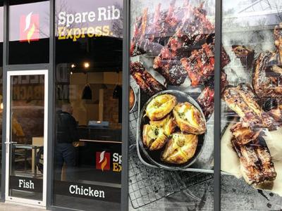 Voorkant van een Spare Ribs Express-restaurant met reclames voor spareribs, aardappelen en diverse gerechten.