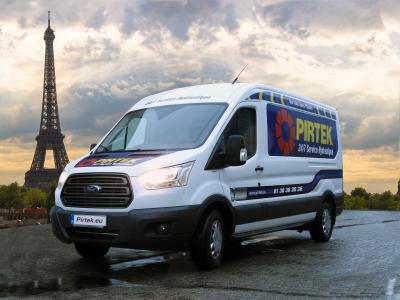 Een Pirtek bestelwagen geparkeerd met de Eiffeltoren op de achtergrond in Parijs.