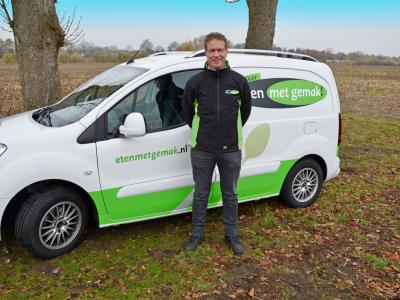 Man staat naast een bestelwagen van Eten met gemak in een natuurlijke omgeving.