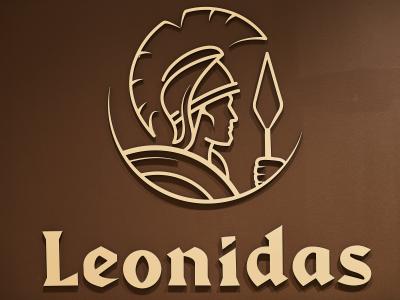 Leonidas-logo met afbeelding van een krijger en tekst op een bruine achtergrond.