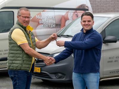 Twee mannen schudden handen bij de overhandiging van sleutels voor een Speedheat bestelbus.