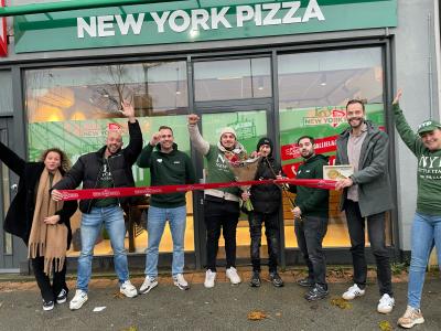 Team viert feestelijke opening van de New York Pizza vestiging in Utrecht Balijenlaan met een lint- en bloemenscène.