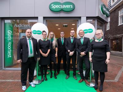 Specsavers-team poseert voor de nieuwe winkel in Delfzijl met ballonnen en groene loper.