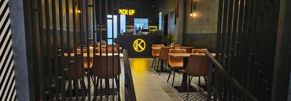 Interieur van een Kingribs restaurant met moderne zitplaatsen en een balie voor afhaalbestellingen.