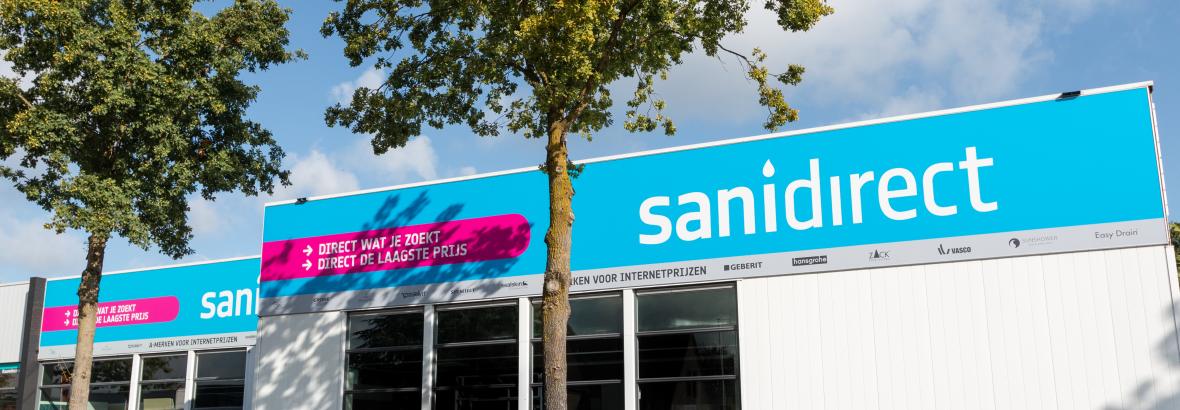 Vooraanzicht van het Sanidirect-winkelpand met opvallende blauwe en roze gevelborden.