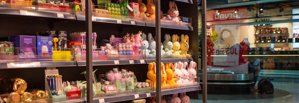 Interieur van een Bruna-winkel met schappen vol kleurrijk speelgoed en schrijfwaren in een moderne setting.